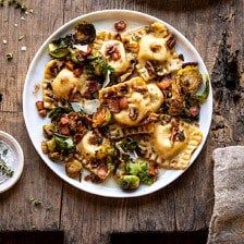 two white plates filled with food on top of a wooden table next to silverware