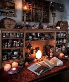 an open book sitting on top of a table next to candles and other items in a room