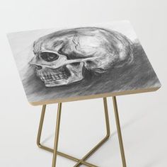 a drawing of a skull sitting on top of a wooden table with a metal stand