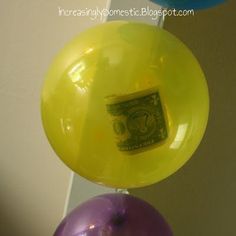 two balloons with money sticking out of them