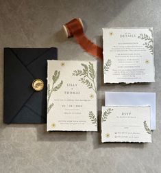 the wedding stationery is set up with an envelope, ribbon and wax stamp on it