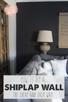 a bed sitting in a bedroom next to a wall with writing on it and the words how to diy a shiplap wall, the cheap and easy way