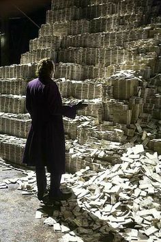 a man standing in front of stacks of bricks