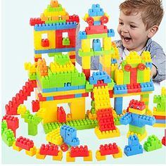 a young boy playing with legos in the shape of a castle and building blocks