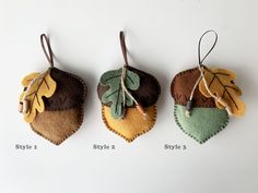 three felt leaf ornaments hanging from strings