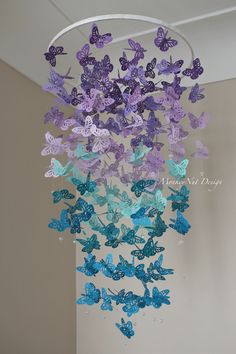 purple and blue butterflies are hanging from a circular chandelier in the corner of a room