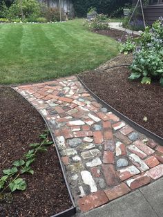 a brick path in the middle of a garden