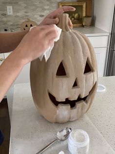 someone is carving a pumpkin for halloween