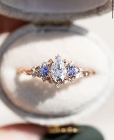 an engagement ring with three diamonds and blue sapphires