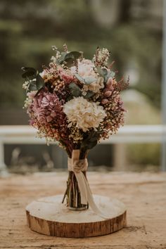 a bouquet of flowers sitting on top of a wooden table