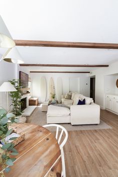 a living room filled with furniture and a wooden table in front of a white couch