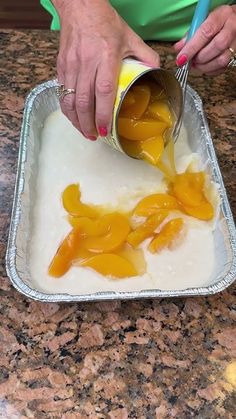 a person pouring orange juice into a pan