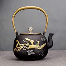 a black teapot with gold dragon designs on it