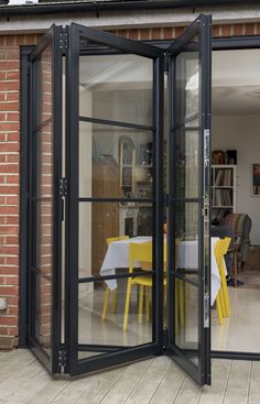 an open glass door leading into a dining room