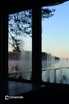 a window with water and trees in the background