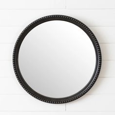 a round mirror hanging on the wall