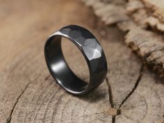 a black ring sitting on top of a piece of wood