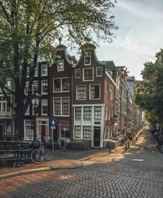 an old brick street lined with parked bicycles and buildings in the background, on a sunny day