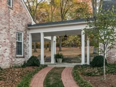 a brick house with white columns and pillars