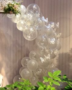 a bunch of balloons that are hanging from a ceiling with flowers on top of them