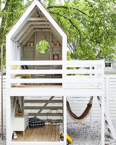 a white house with a hammock on the roof and stairs leading up to it