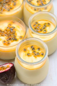 four desserts in small glasses with fruit on the side