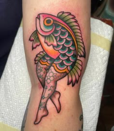 a colorful fish tattoo on the leg