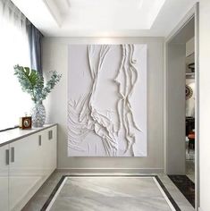 a large white abstract painting on the wall in a modern room with grey and white flooring