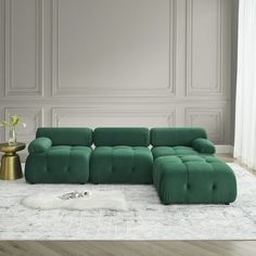 a green couch sitting on top of a white rug