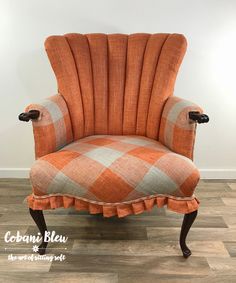 an orange chair with a book on it and a flower sitting on top of it