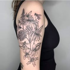 a woman's arm with flowers and bees on it