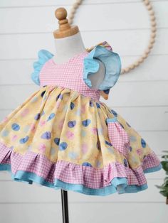 Girls Easter Dress This adorable Easter dress features a fun Easter Egg print with pretty pink gingham. Pockets for putting treasures in! Back is Elastic and ties in a pretty bow. This is a vintage length dress. Bloomers can be added on! Easter Dresses With Ruffles And Short Sleeves, Cute Gingham Dress With Short Sleeves, Cute Short Sleeve Gingham Dress, Cute Plaid Short Sleeve Dress, Playful Multicolor Dress For Picnic, Playful Gingham Dress For Playtime, Playful Gingham Dress For Spring, Playful Gingham Dress With Ruffles, Playful Easter Dresses For Playtime