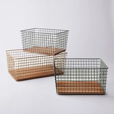 three metal baskets sitting on top of a white table next to each other, one holding bread