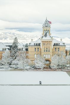 a large building with a clock tower in the snow