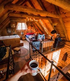 a person holding a cup of coffee in their hand while looking down at the loft