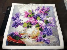 a cross stitch picture with flowers on it