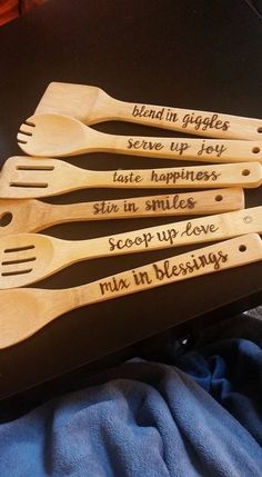 four wooden utensils with writing on them