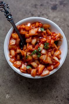 a white bowl filled with food on top of a table