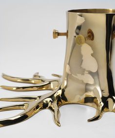 a gold colored cup with several forks sticking out of it