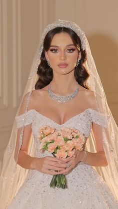 a woman in a wedding dress with flowers on her bouquet and veil over her head