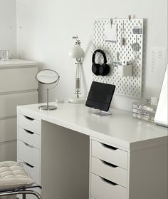 a white desk topped with drawers and a laptop computer