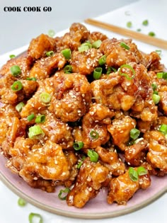 chicken with sesame seeds and green onions on a plate