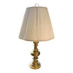 a gold lamp with a white shade on it's base and a corded lampshade