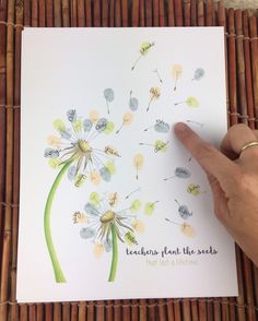 a hand pointing at a dandelion card with the words, teachers plant the seeds