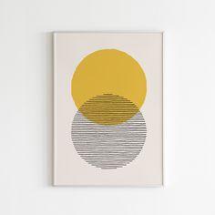 a yellow and black circle on a white wall above a framed art print with horizontal lines