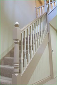 a white stair case next to a set of stairs