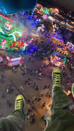 a person's feet are shown in front of an aerial view of a carnival