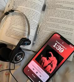 an open book and headphones on a bed