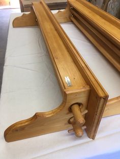 a wooden bench sitting on top of a white cloth covered table next to a mirror