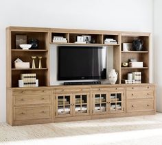 a large entertainment center with bookshelves and a flat screen tv on the wall